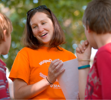 Instructor leading kid's class outside. 