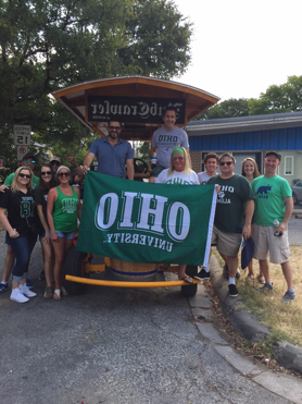 A group of Alumnus holding up a flag