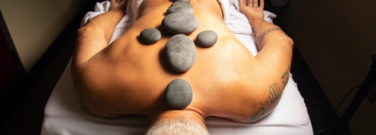 Massage client with hot stones on back